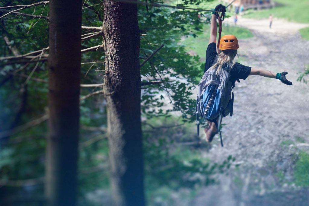 En jente som kjører zipline i skogen. Her finner du våre beste forslag til 30 års gaver.