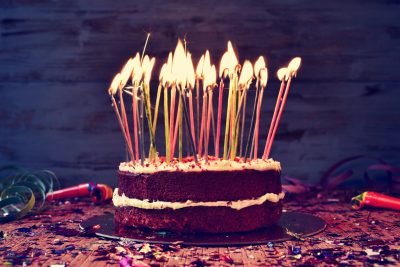Bursdagskake med brennende lys. Her finner du gavetips når du er på jakt etter 50 års gave til mann 2017.