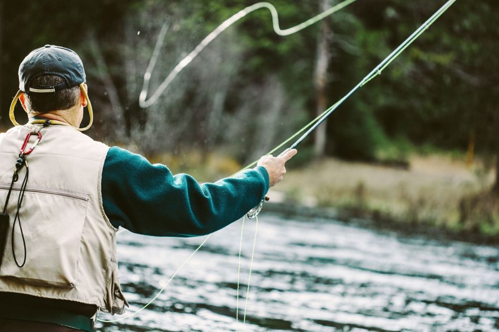 En mann som fluefisker i en elv. En perfekt 50 års gave til mann 2017.