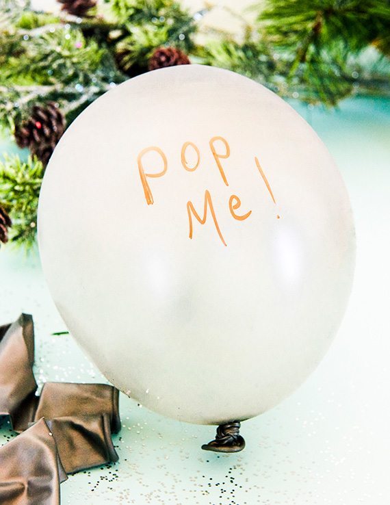 Gave gjemt inne i en hvit ballong med teksten "Pop me". Se våre tips til kreativ innpakning av gaver.