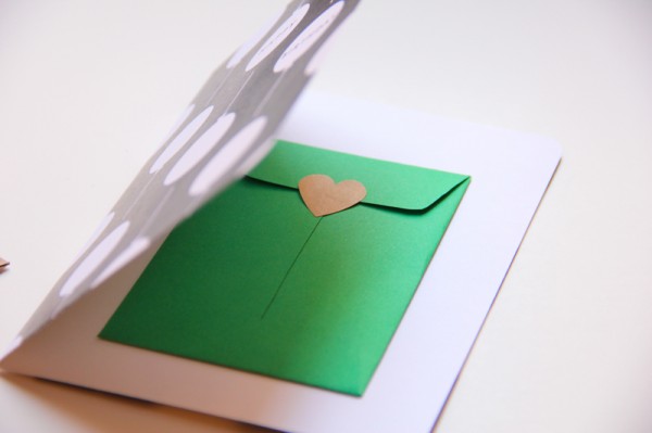 Et kort med en grønn konvolutt med hjerte stempel. Se våre tips til kreativ innpakning av gaver.