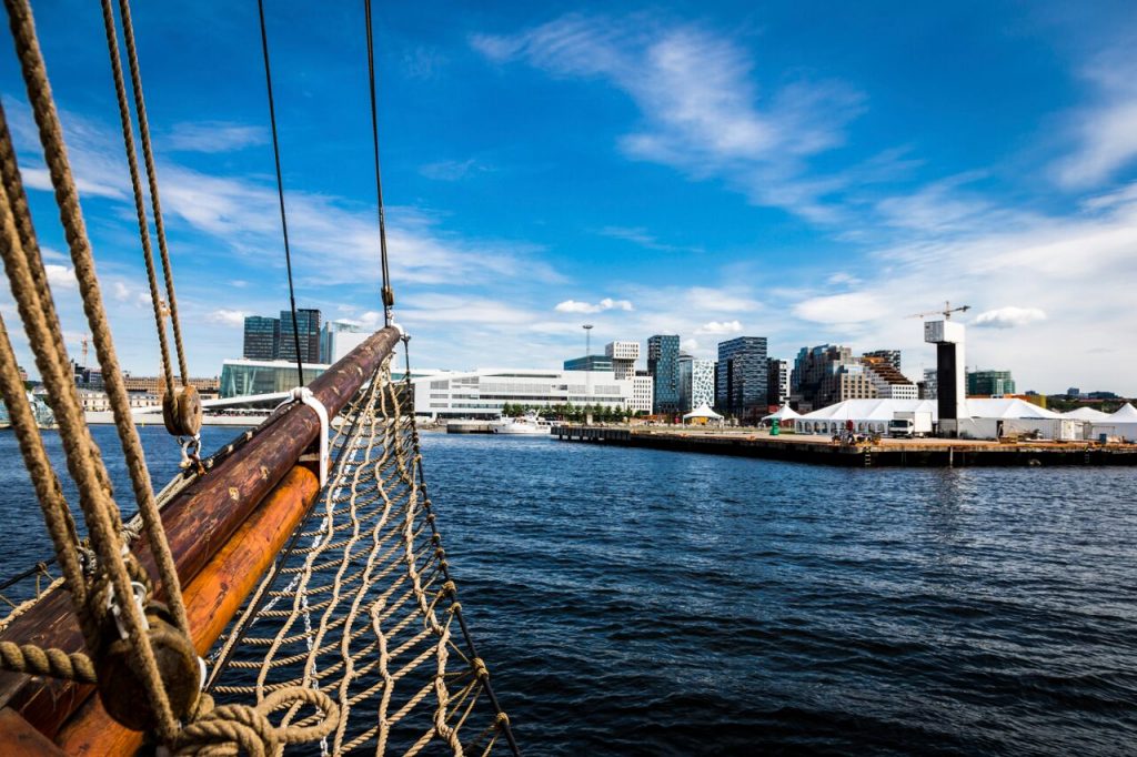 En båt på tur i Oslofjorden med utsikt til operaen og Bjørvika. Ting å gjøre i Oslo om sommeren.