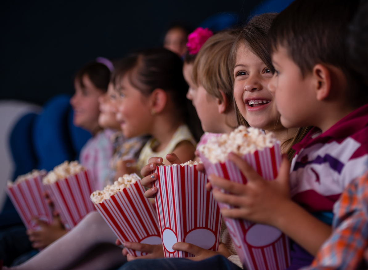 En gruppe barn på kino med popcorn. Aktiviteter i Bergen finner du her.