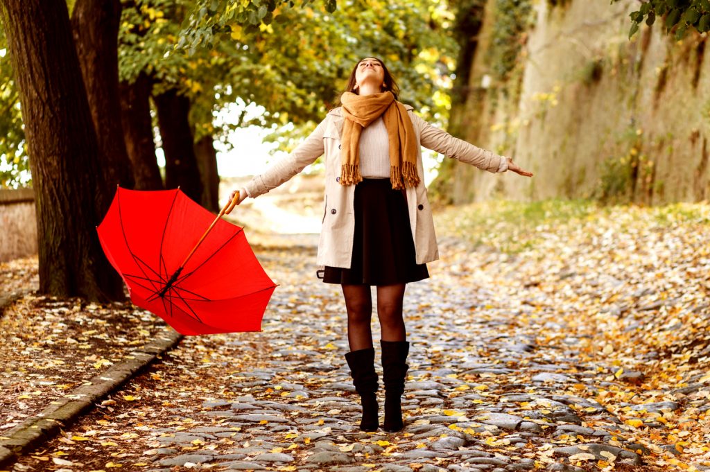 Ta med deg feriefølelsen inn i hverdagen. Glad jente i høstløvet med paraply.