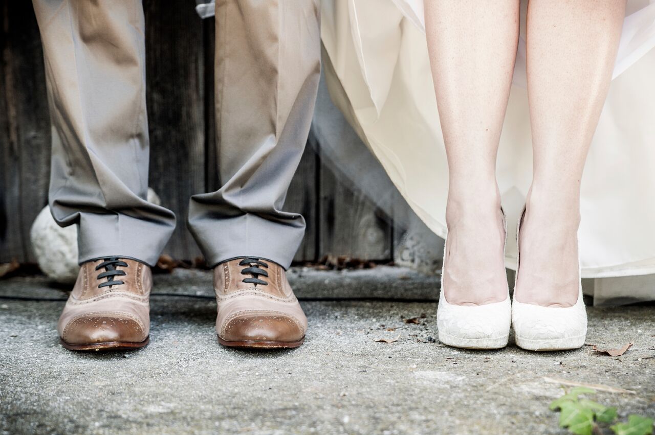 Brudepar på kirketrappen, fra knærne og ned. Våre beste tips til bryllupsgave vil få brudeparet til å danse av glede.