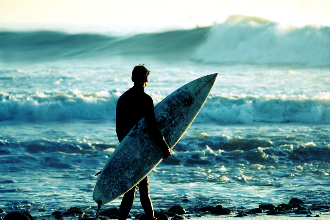 Surfer som ser utover havet. En perfekt gave under 500 kroner til en som vil prøve noe nytt