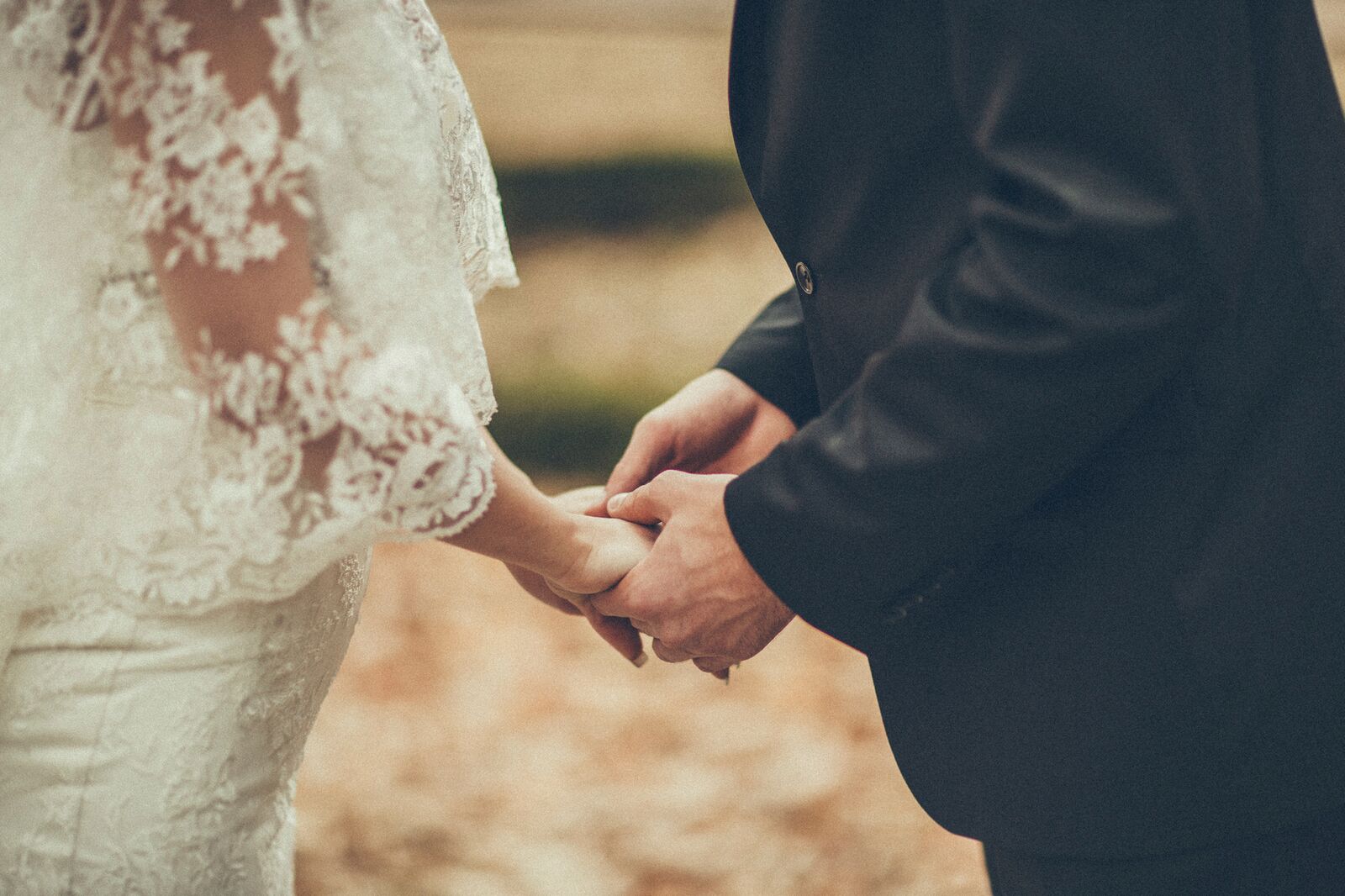 Brudepar som holder hender. Her får du tips så du kan gi en kreativ bryllupsgave til de nygifte.