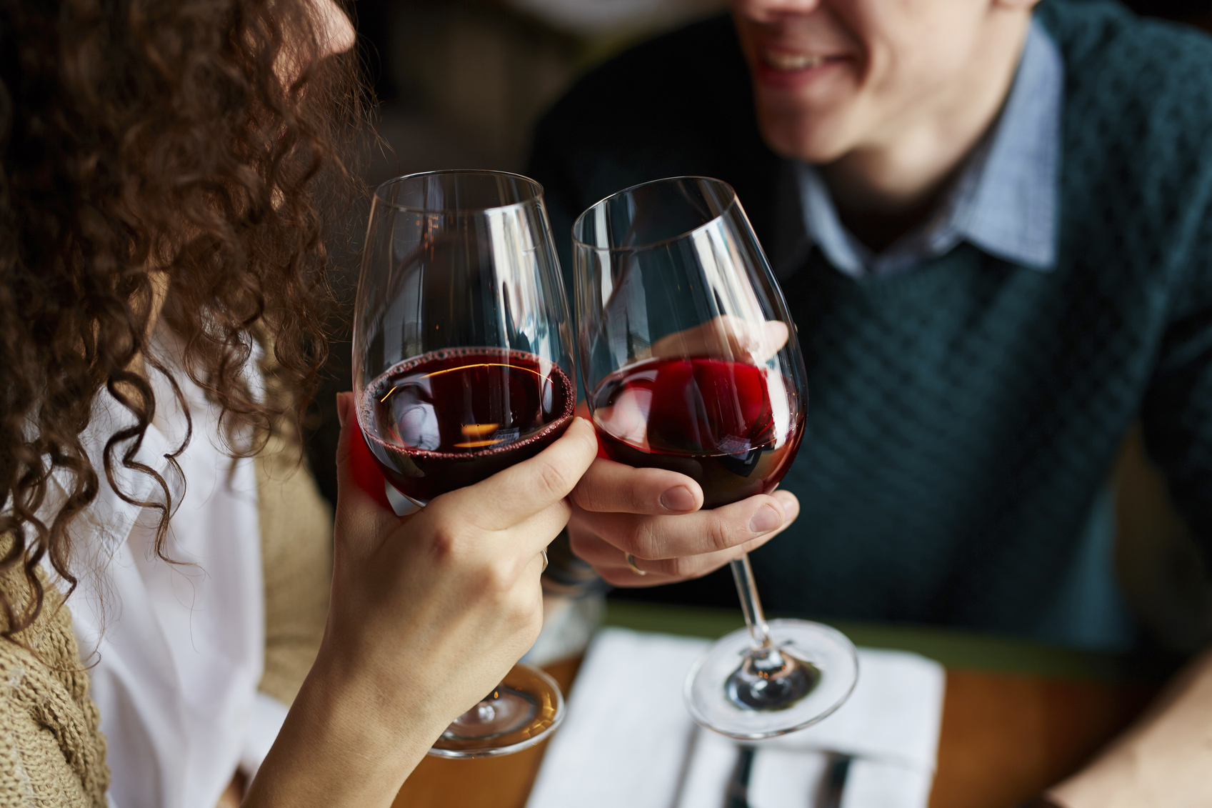 Par som skåler i rødvin og smiler. Her finner du gavetips så du kan finne en perfekt gave til kjæresten