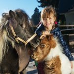 En liten jente med to ponnier. Her får du våre beste gavetips til barn.