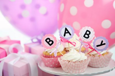 Muffins og ballonger på et bord med babybokstaver. Babshower gavetips finner du her.