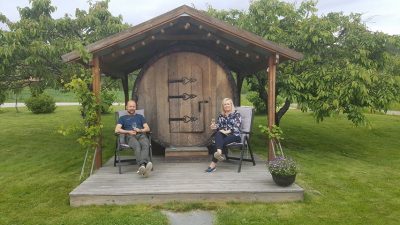 Et par utenfor vintønn på en norsk vingård.